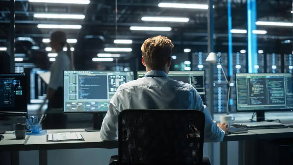 IT specialist working on multiple monitors 
