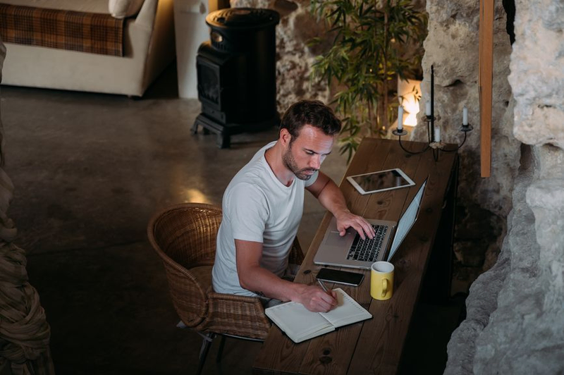 Developer working on a laptop and taking notes